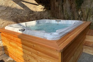 Ein Whirlpool mit Holzverkleidung, eingebettet in eine natürliche Umgebung.