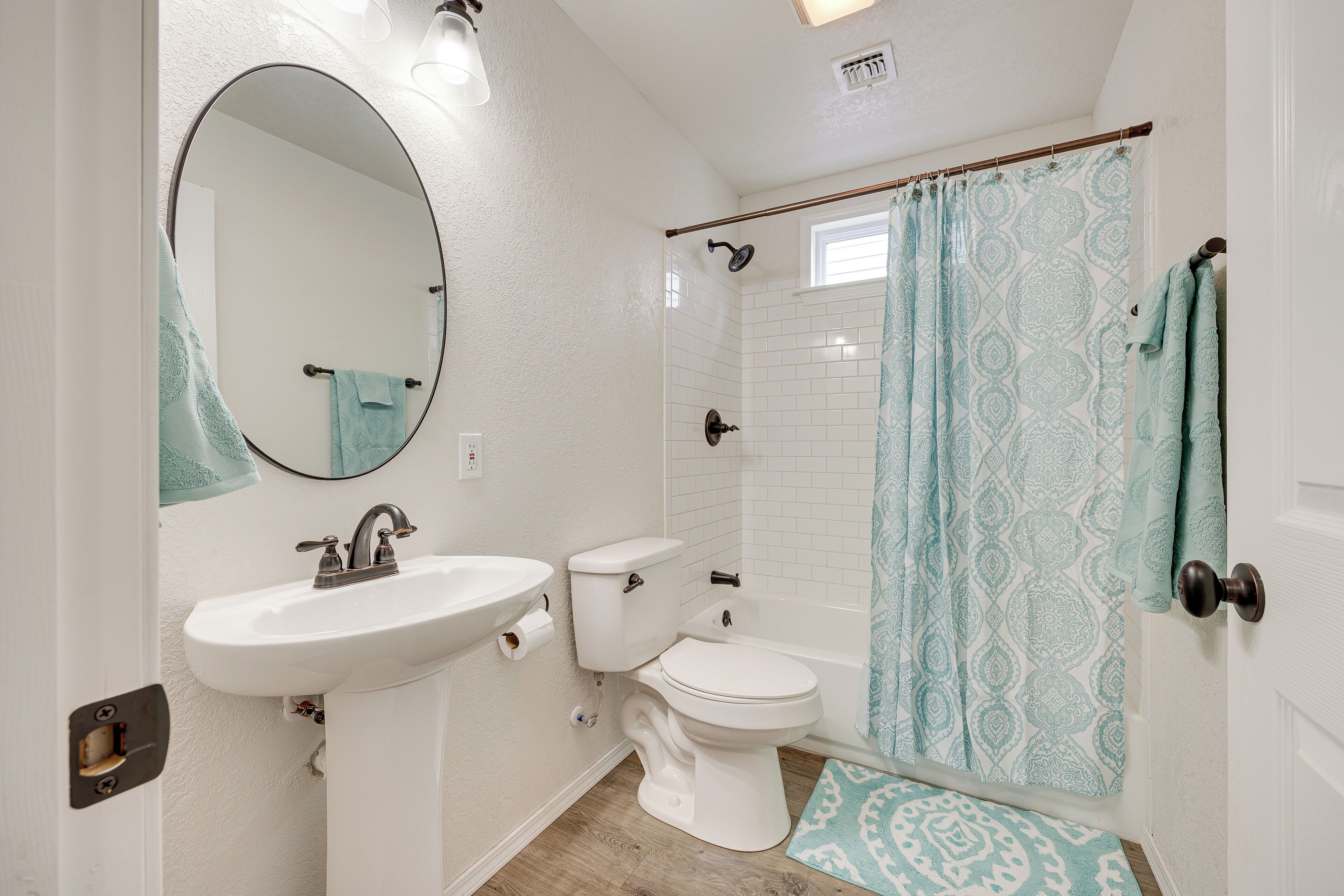 A bathroom with a white sink, toilet, and bathtub.
