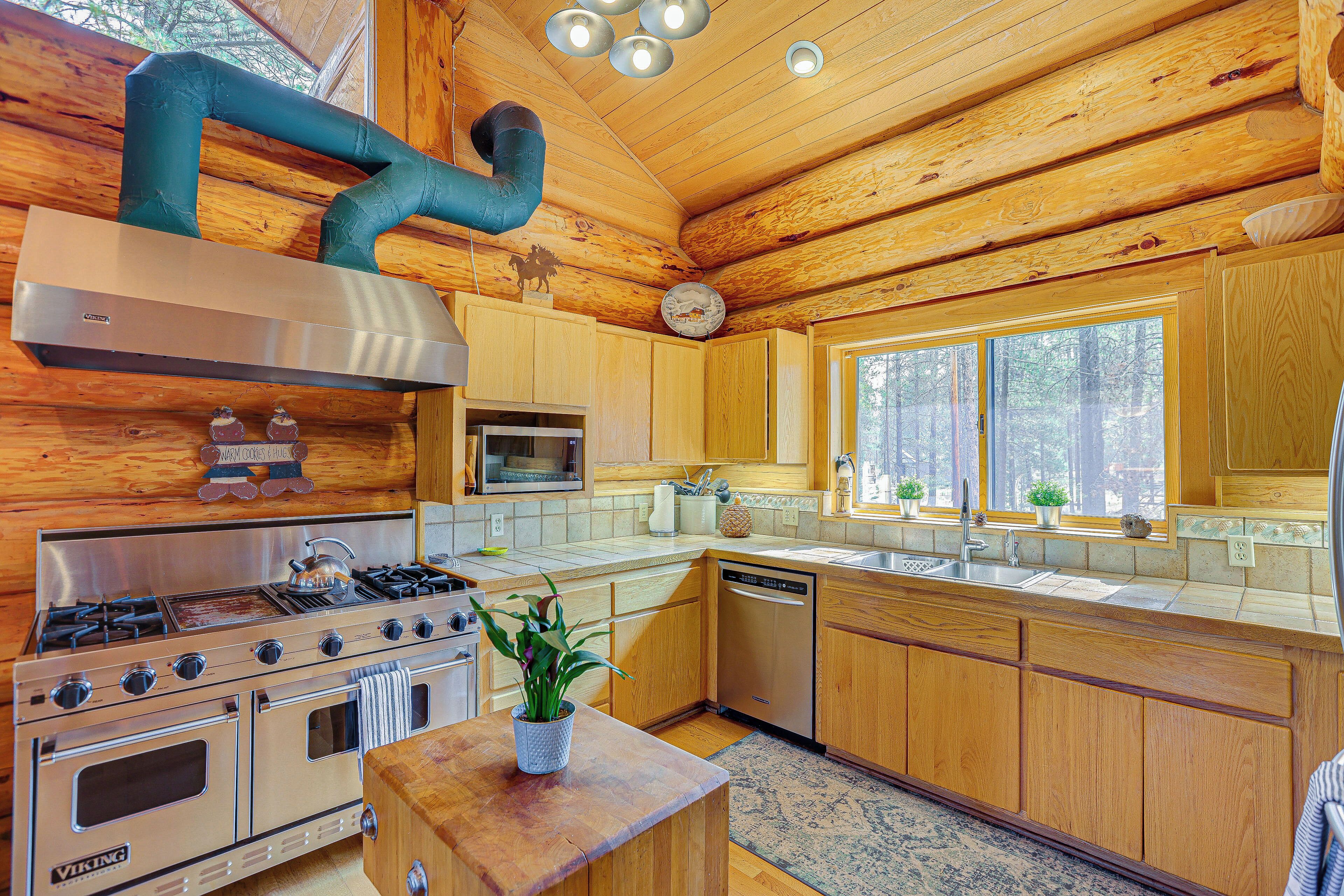A kitchen with wooden cabinets, a stainless steel stove, and a dishwasher.