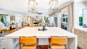 A spacious kitchen with a large island, pendant lighting, and a view to the dining area. - Heated SaltWater Pool+HotTub! Golf Cart+1 Mile To Beach! (Fort Lauderdale)