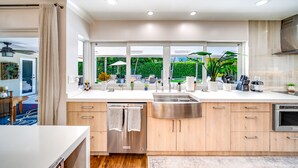 A modern kitchen with a dishwasher, stainless steel sink, and wooden cabinets. - Heated SaltWater Pool+HotTub! Golf Cart+1 Mile To Beach! (Fort Lauderdale)