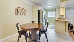 A dining area with a round table and chairs, a ceiling fan, and a kitchen in the background. - Welcoming Sarasota Vacation Rental w/ Pool! (Sarasota)