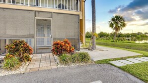 A modern building with a balcony, a door, and a well-maintained garden with shrubs and a palm tree. - Welcoming Sarasota Vacation Rental w/ Pool! (Sarasota)