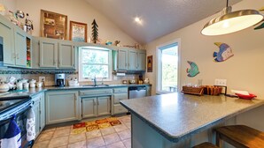 A kitchen with light blue cabinets, a granite countertop, and a window. - Pet-friendly New Concord Vacation Rental on Lake! (New Concord)