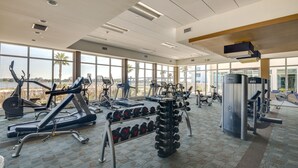 A gym with cardio machines, weightlifting equipment, and dumbbells. - Luxe Resort Condo - 2 Mi to Daytona Beach! (Holly Hill)