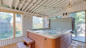 A hot tub with a wooden exterior, a wooden deck, and a view of a backyard. - Spacious Aurora Retreat w/ Game Room + Hot Tub! (Aurora)