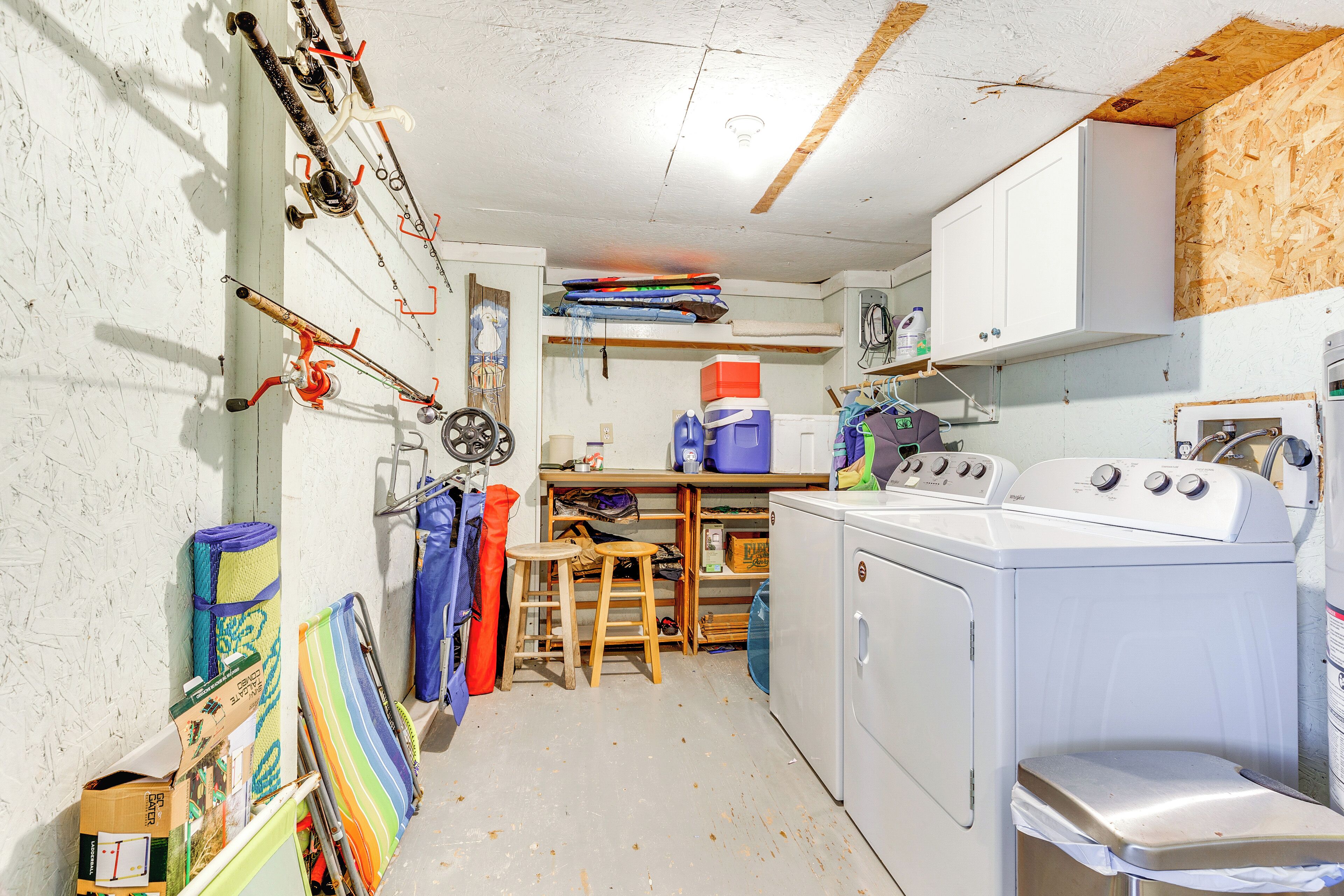 A laundry room with a washing machine, a dryer, and a small table with chairs.