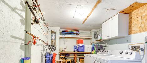 A laundry room with a washing machine, a dryer, and a small table with chairs.
