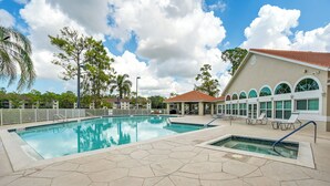 A swimming pool with a tiled deck, lounge chairs, and a building with arched windows. - 3 Mi to Beaches: Naples Condo w/ Pool Access! (Naples)