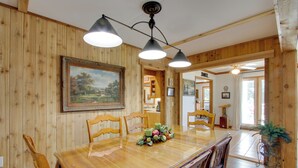 A dining area with a wooden table, chairs, and a painting on the wall. - Waterfront Home Near Wilson Lake w/ Covered Porch! (Killen)