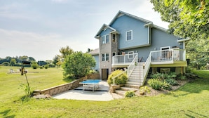 Une maison à deux étages avec un balcon, une petite piscine et une pelouse bien entretenue.