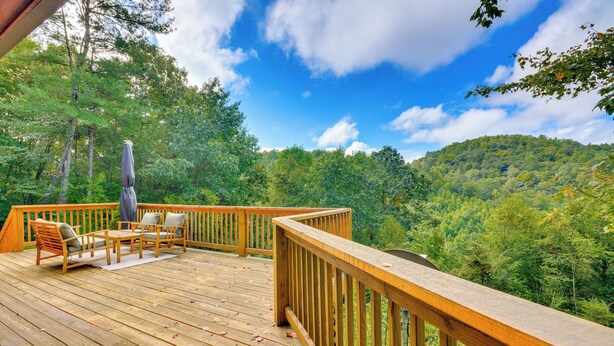 A wooden deck with outdoor furniture and a view of a forested hillside. - Mtn View + Fire Pit: Pet-friendly Woodlawn Cabin! (Woodlawn)