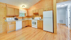 A kitchen with wooden cabinets, a microwave, stove, and refrigerator. - Mtn View + Fire Pit: Pet-friendly Woodlawn Cabin! (Woodlawn)