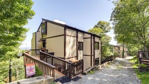 A two-story building with a wooden deck and a gravel path leading to the entrance. - Hike, Ski & Fish! Sunset-view Condo in Beech Mtn (Banner Elk)