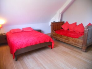 Une chambre à coucher avec un lit en bois et une couvre-lit rouge.