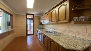 Una cocina con armarios de madera, encimera de granito y salpicadero de azulejos.