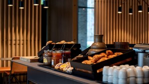 Een ontbijtbuffet met gebak, jam en toevoegingen.