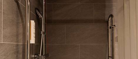 A shower with a handheld showerhead, a handheld shower control, and a handheld shower hose.