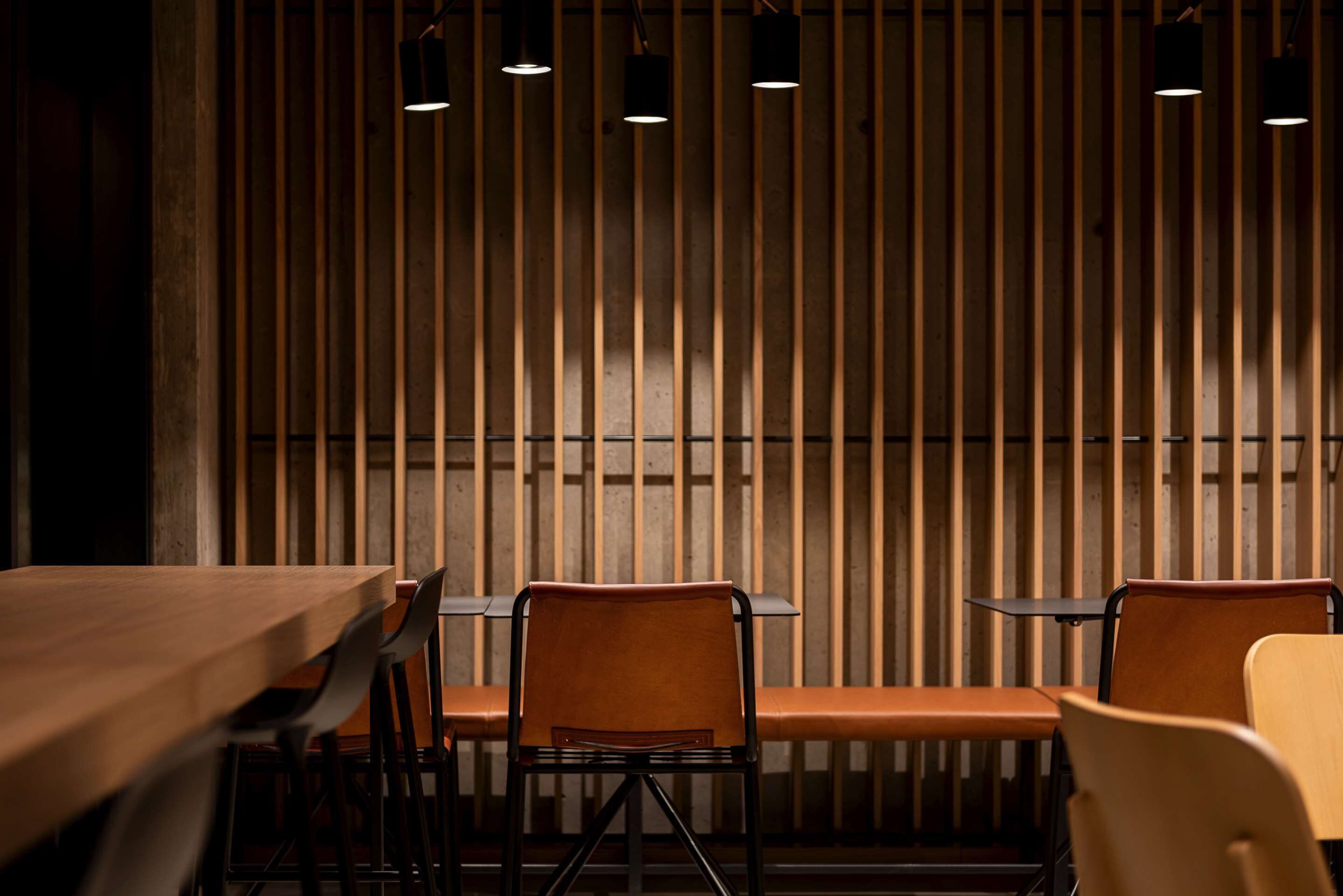 L’intérieur d’un restaurant présente des murs recouverts de lambris en bois, ainsi que de nombreuses tables et chaises.