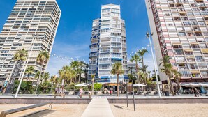 Un área urbana moderna con edificios altos, palmeras y terrazas al aire libre.