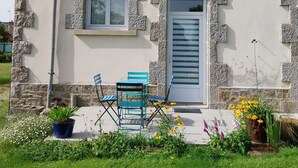 A two-story house with stone walls, a grey door, and a small balcony. - Gîte-appartement sur la Côte D'emeraude (Beaussais-sur-Mer)
