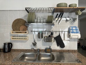 Geladeira, fogão, talheres/pratos/utensílios de cozinha