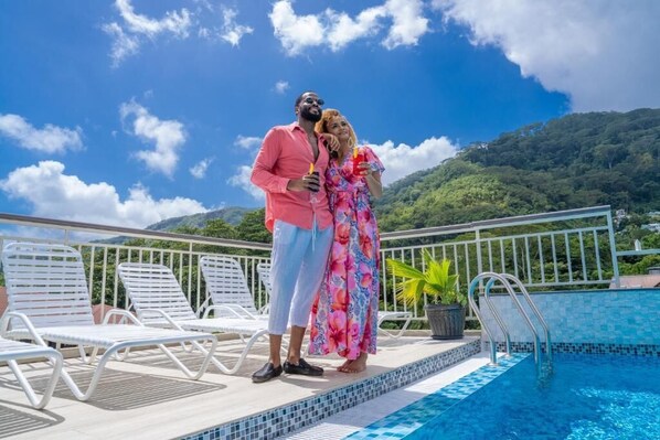 Una piscina al aire libre, sillones reclinables de piscina