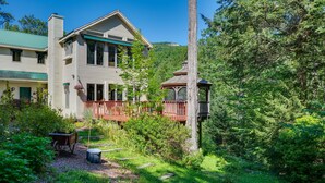 A two-story house with a green roof, a wooden deck, and a gazebo. - Charming Thornton Escape w/ Sauna + Gazebo! (Thornton)
