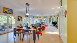 A spacious living area with a dining table, chairs, and a sofa. There are large windows and a balcony. - Charming Thornton Escape w/ Sauna + Gazebo! (Thornton)