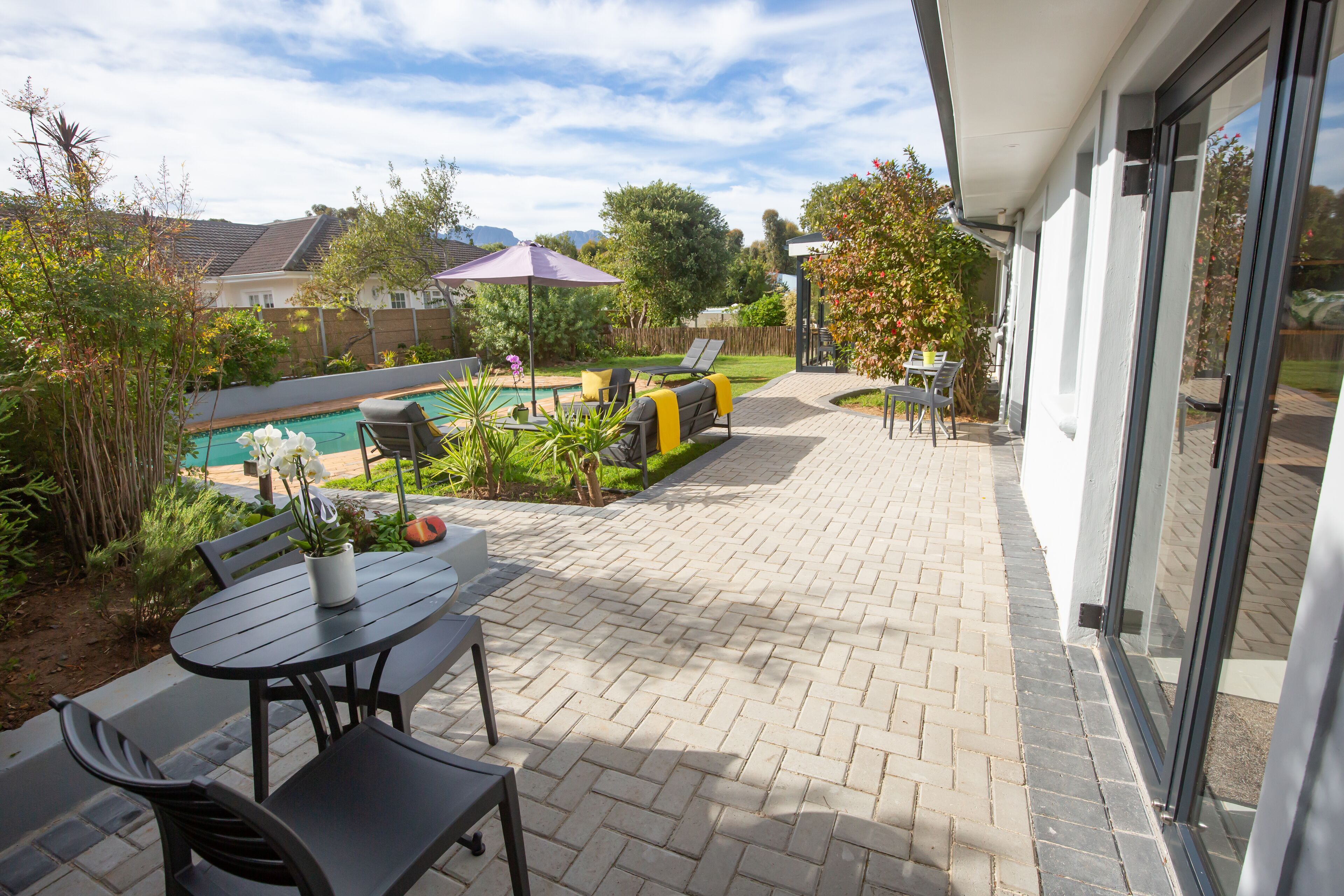 A patio area with a pool, outdoor furniture, and a view of the neighborhood.