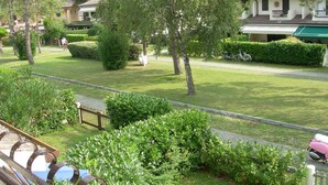 A residential area with well-maintained lawns, trees, and a pathway. - Precious Villa With Private Garden and Barbecue (Caorle)