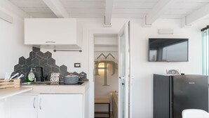 Een moderne keuken met een zwart betegelde achterwand, een ingebouwde oven en een zwarte koelkast.