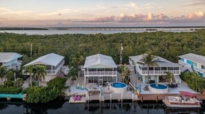 A coastal property with multiple buildings, a swimming pool, and a dock with boats.