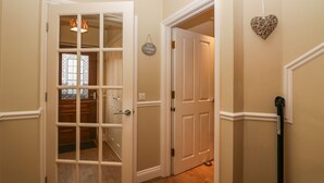 A hallway with a wooden door, a white door, and a heart-shaped decoration on the wall. - Castle Crag (Keswick)