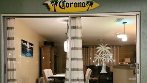 A dining area with a table and chairs, a wooden cabinet, and a decorative palm tree. - Tropical Breeze  Heated Pool, Canal Home, King bed. (Cape Coral)