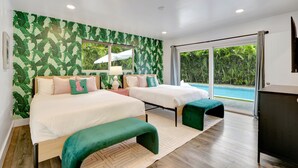A modern bedroom with two beds, a large window, and a view of a swimming pool. - ~NEW~Casa Miami~Luxury Oasis w/ Pool&Game Paradise (Miami)