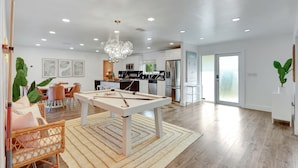 A modern kitchen with white cabinets, a dining area with a pool table, and a large window. - ~NEW~Casa Miami~Luxury Oasis w/ Pool&Game Paradise (Miami)