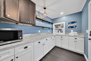 Enjoy cooking in this kitchen with sleek cabinetry, oven, and stainless steel microwave.