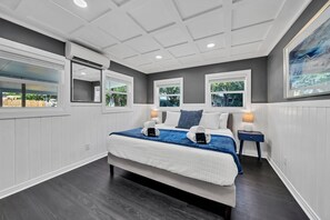 Relax in a serene space with a large bed, bedside tables, and a window offering a view of the outdoors.
