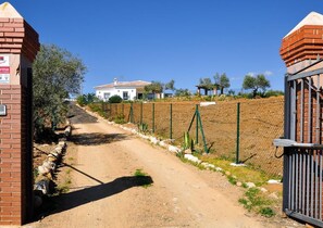 Rustic building surrounded by greenery and a wire fence.