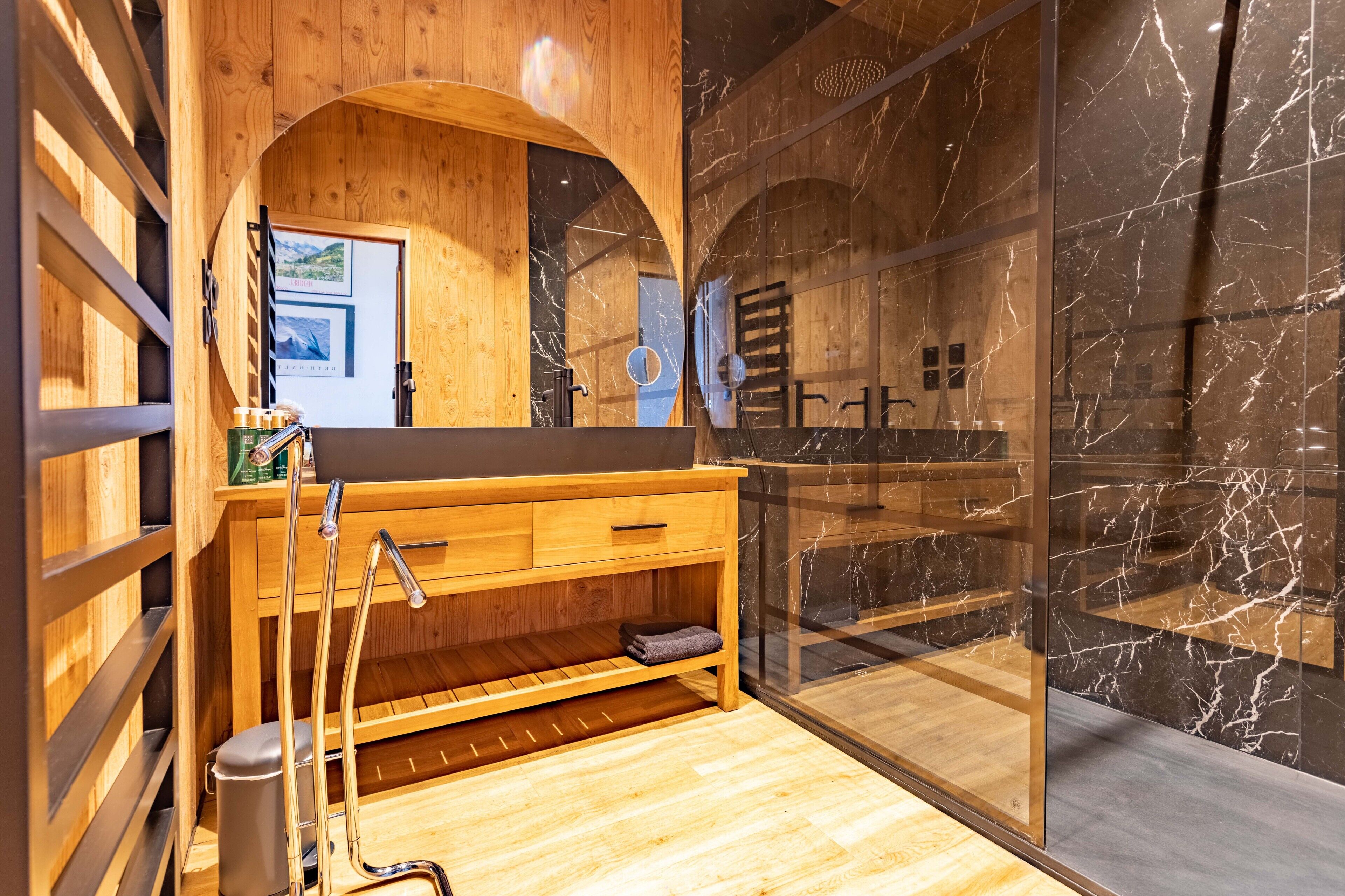 Une coiffeuse en bois avec un plan de travail en marbre, un porte-serviettes et un miroir.