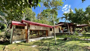 A house with a red roof, stone walls, and a porch.
