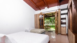 A bedroom with a bed, a wardrobe, and a view of an outdoor area.