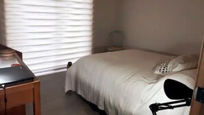 Ein Schlafzimmer mit einem Bett, einem Schreibtisch und einem Stuhl.