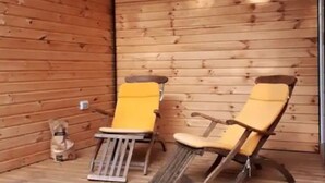 Eine Holzjagdhaus mit zwei gelben Stühlen und einem kleinen Tisch.