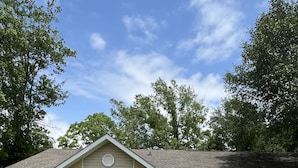 Ein eingeschossiges Haus mit Veranda, Garage und gepflegtem Rasen.