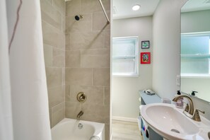 Une salle de bain moderne équipée d’une baignoire, d’une douche et d’un lavabo.