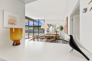 A modern dining area with a large table, chairs, and a view of the outdoors. - California Retro - 1963 Gem on 1/2 an Acre (Palm Desert)