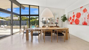 A dining area with a large table, chairs, and a pendant light. - California Retro - 1963 Gem on 1/2 an Acre (Palm Desert)