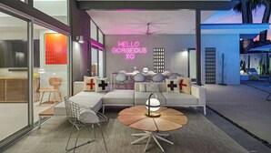 A modern living room with a sofa, chairs, and a coffee table. A neon sign reads "HELLO GORGEOUS XO". - California Retro - 1963 Gem on 1/2 an Acre (Palm Desert)
